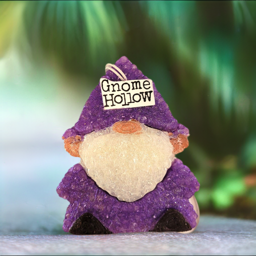 Purple gnome air freshener with a white beard and Gnome Hollow on the hat sitting in front of a green background