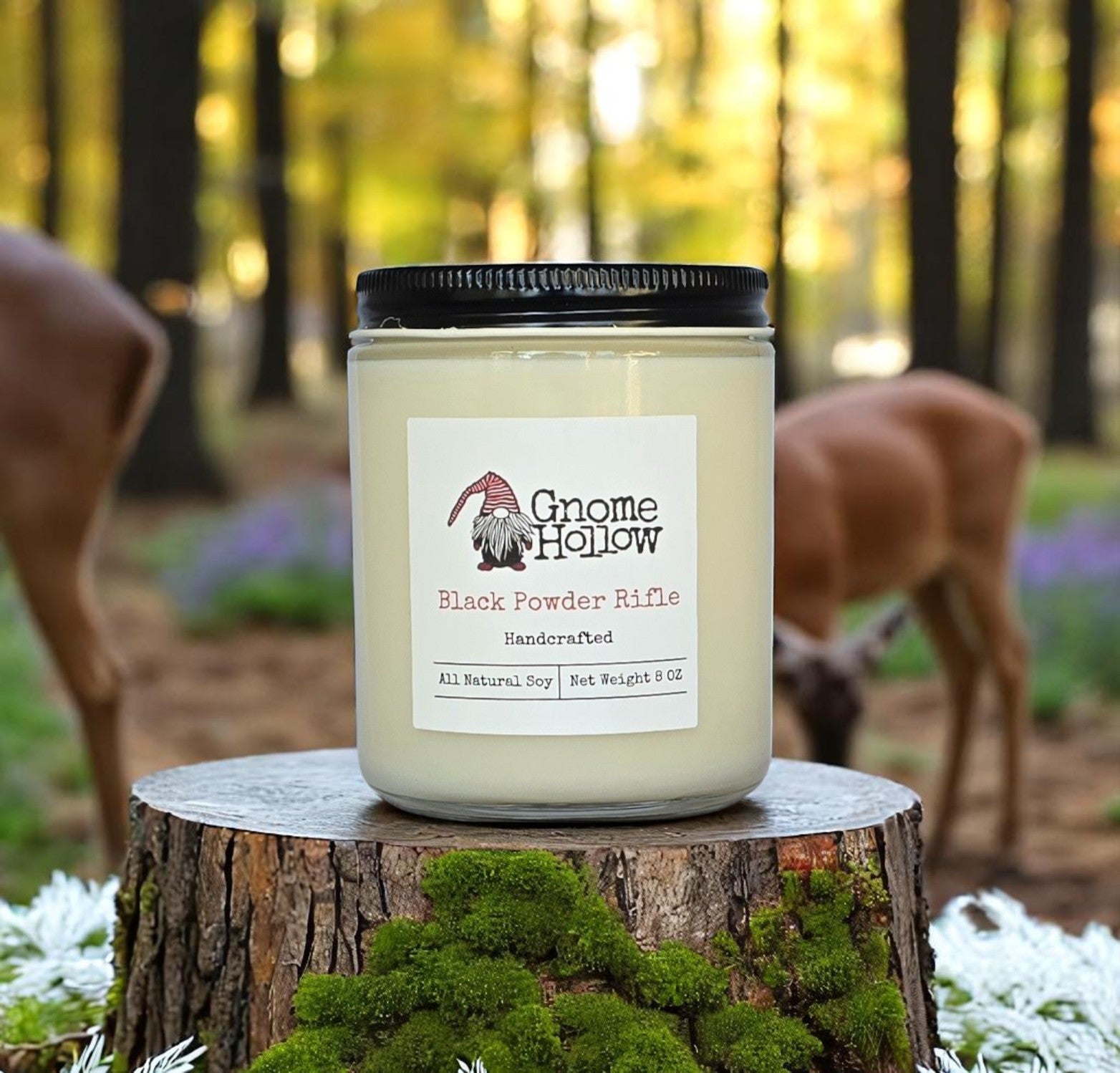 Black Powder Rifle candle sitting on a log with deer in the background