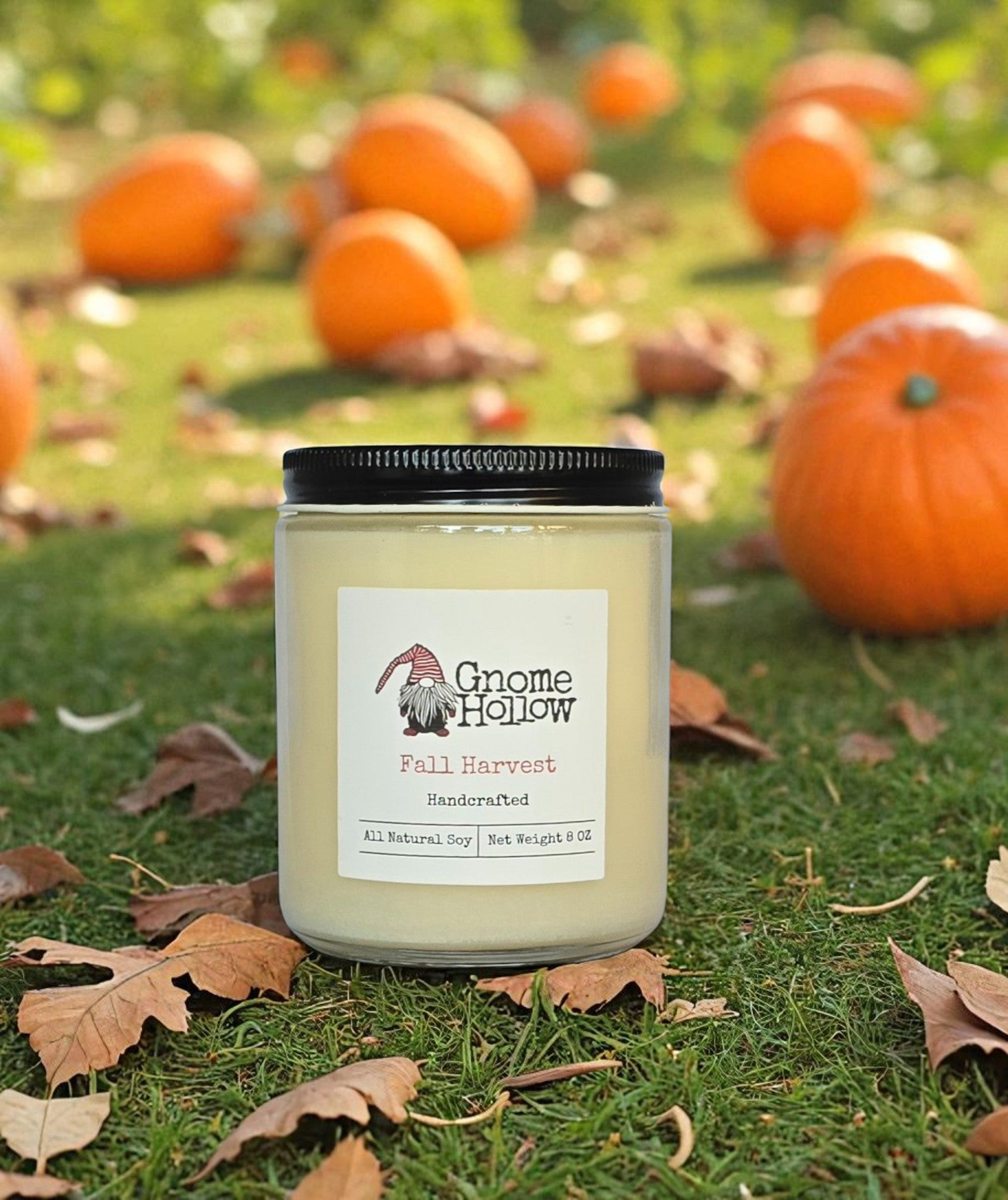 Fall Harvest candle sitting in grass with dried leaves and pumpkins
