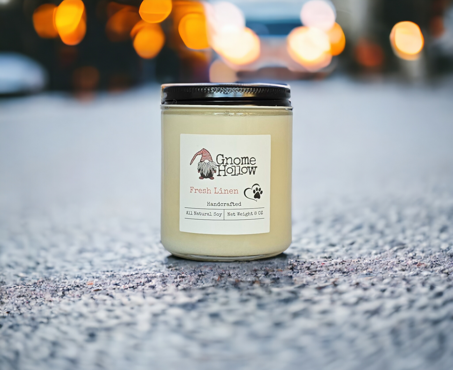 Fresh Linen candle in the middle of a road with blurred headlights in the background