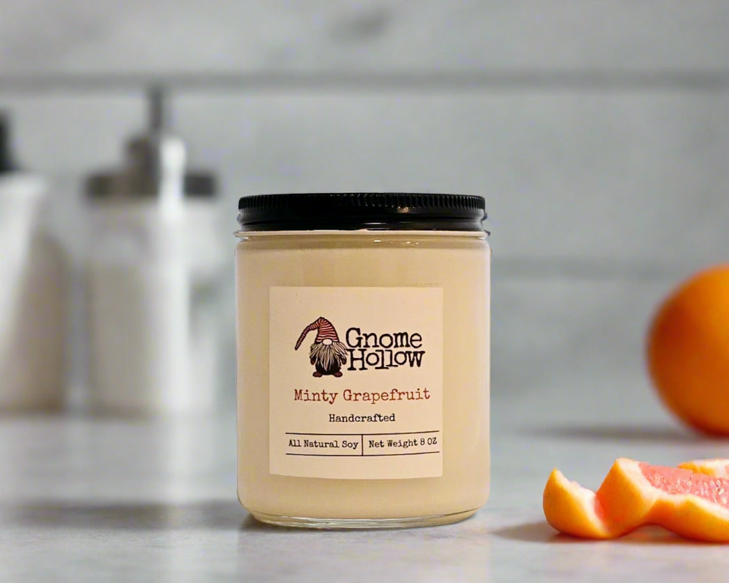Minty Grapefruit candle with sliced grapefruit and a whole grapefruit in the background.