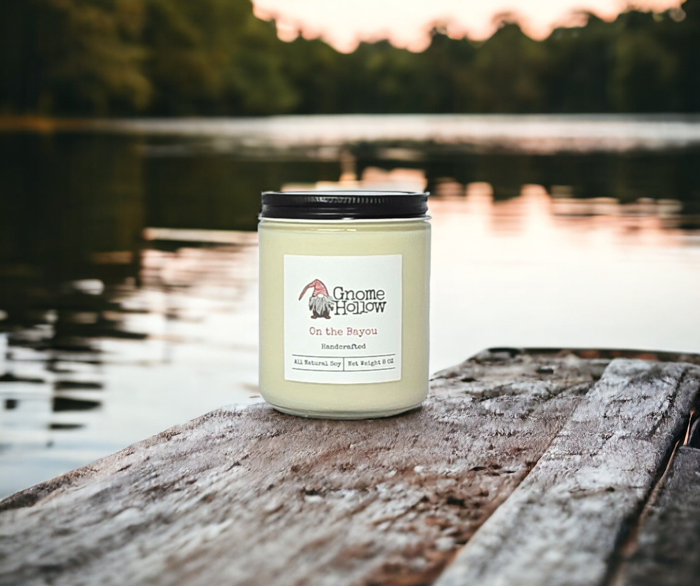On the Bayou candle sitting on a wood pier overlooking a bayou with a treeline in the background