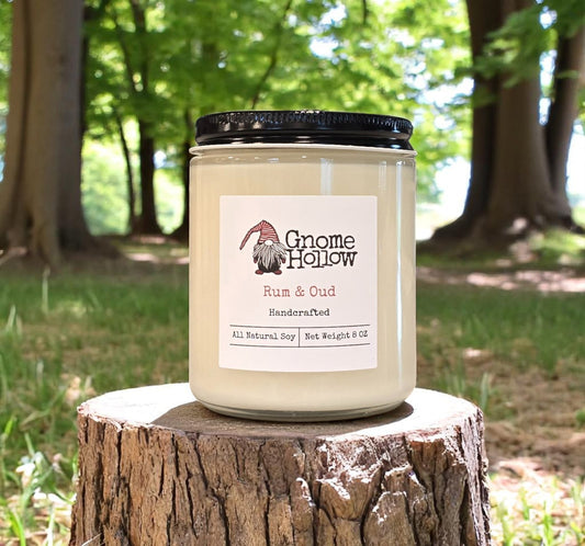 Rum & Oud candle placed on a tree stump outdoors.