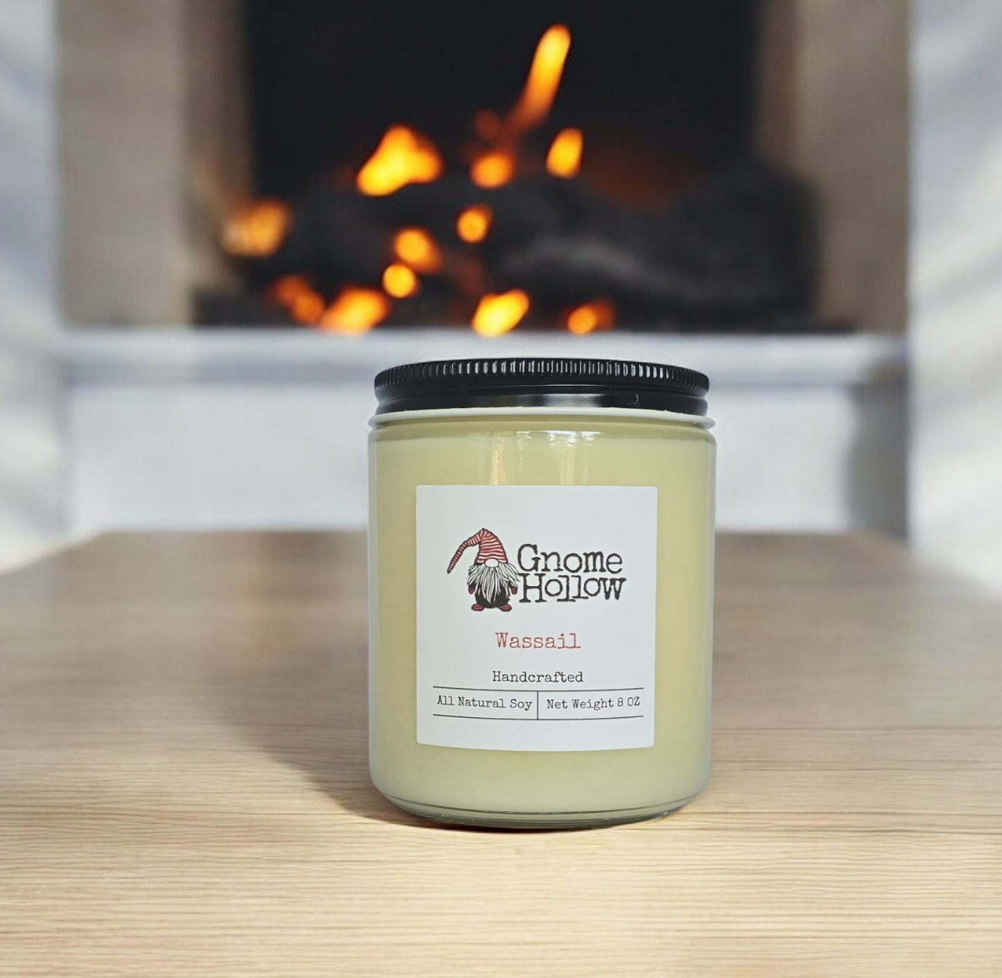 Wassail candle sitting on a light colored wood counter with a fireplace blurred in the background