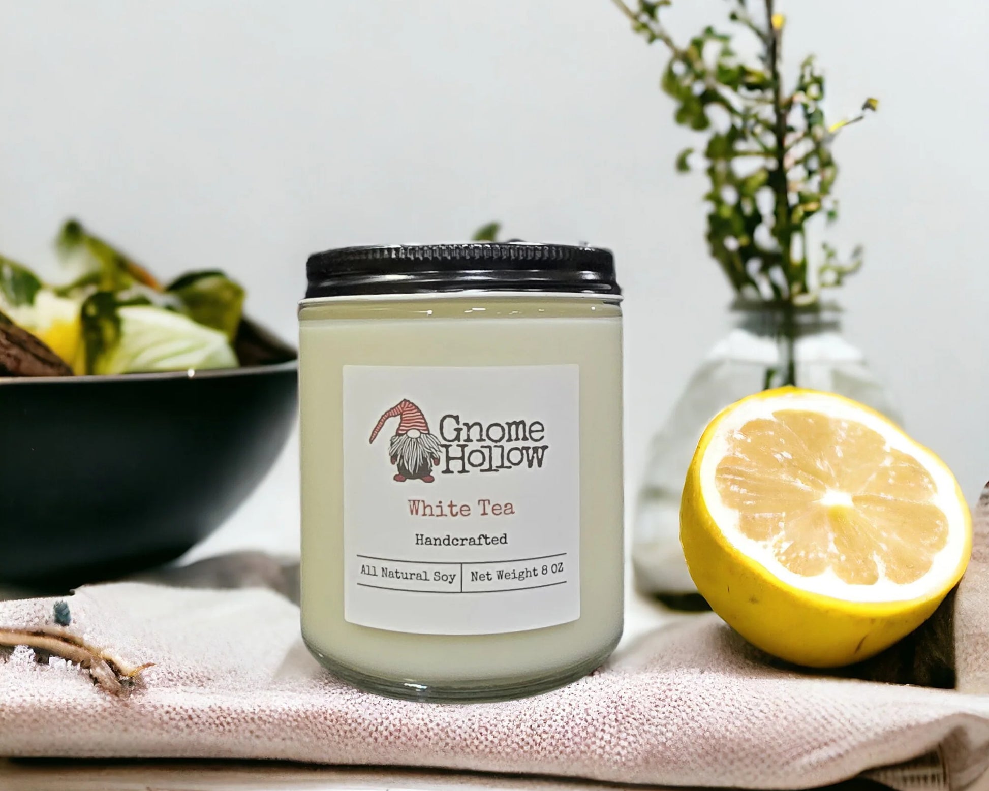White Tea candle on a towel with lemons to the side