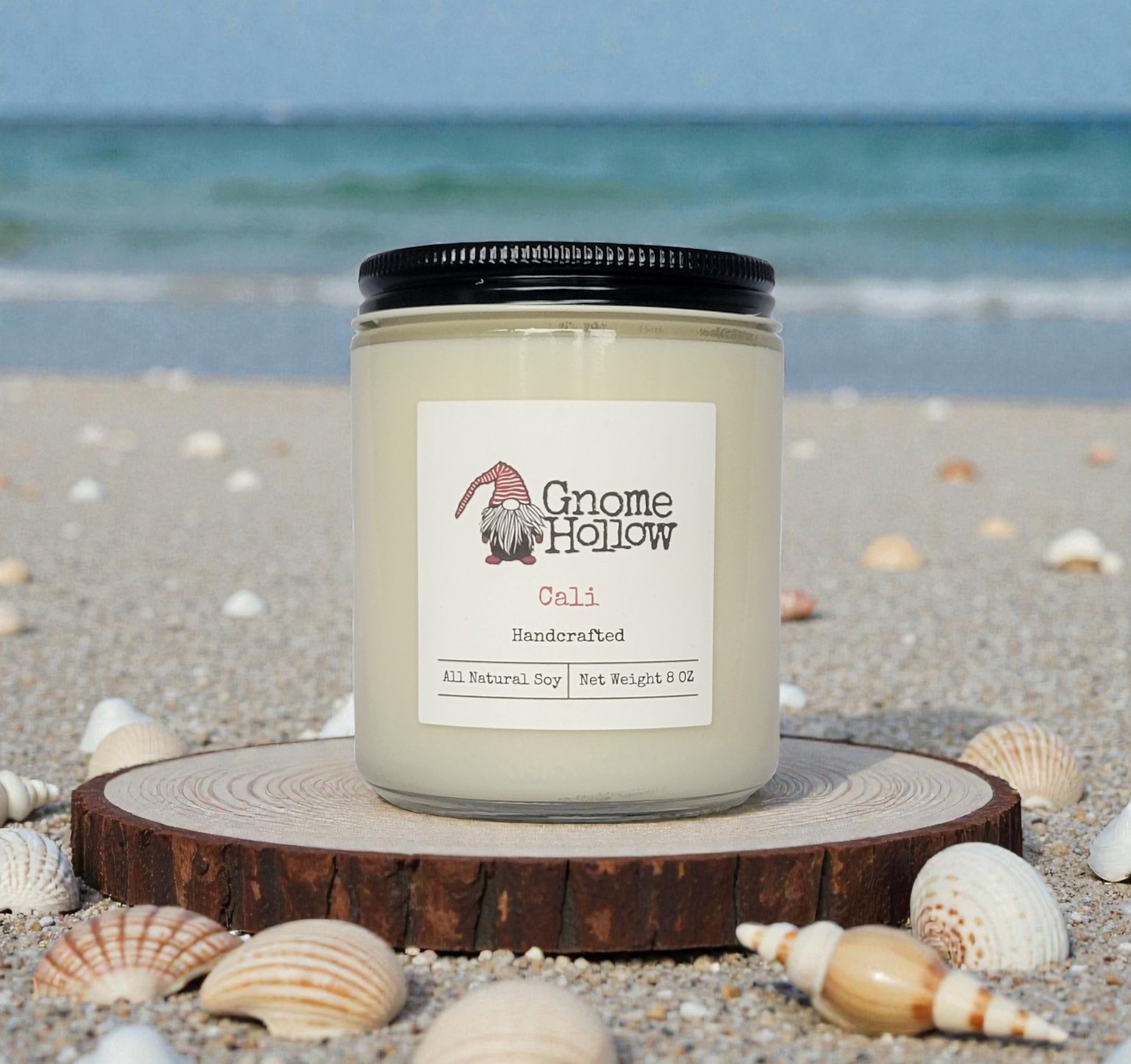 Candle on a round wood piece with ocean in the background