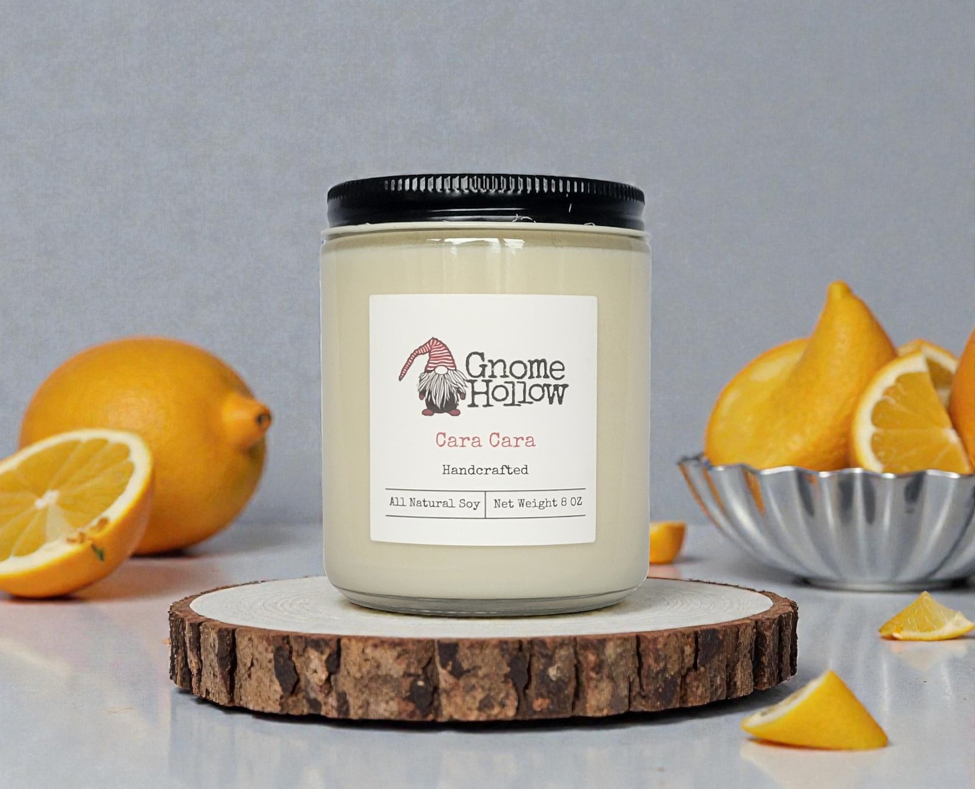 Candle on a wood circle with oranges in the background