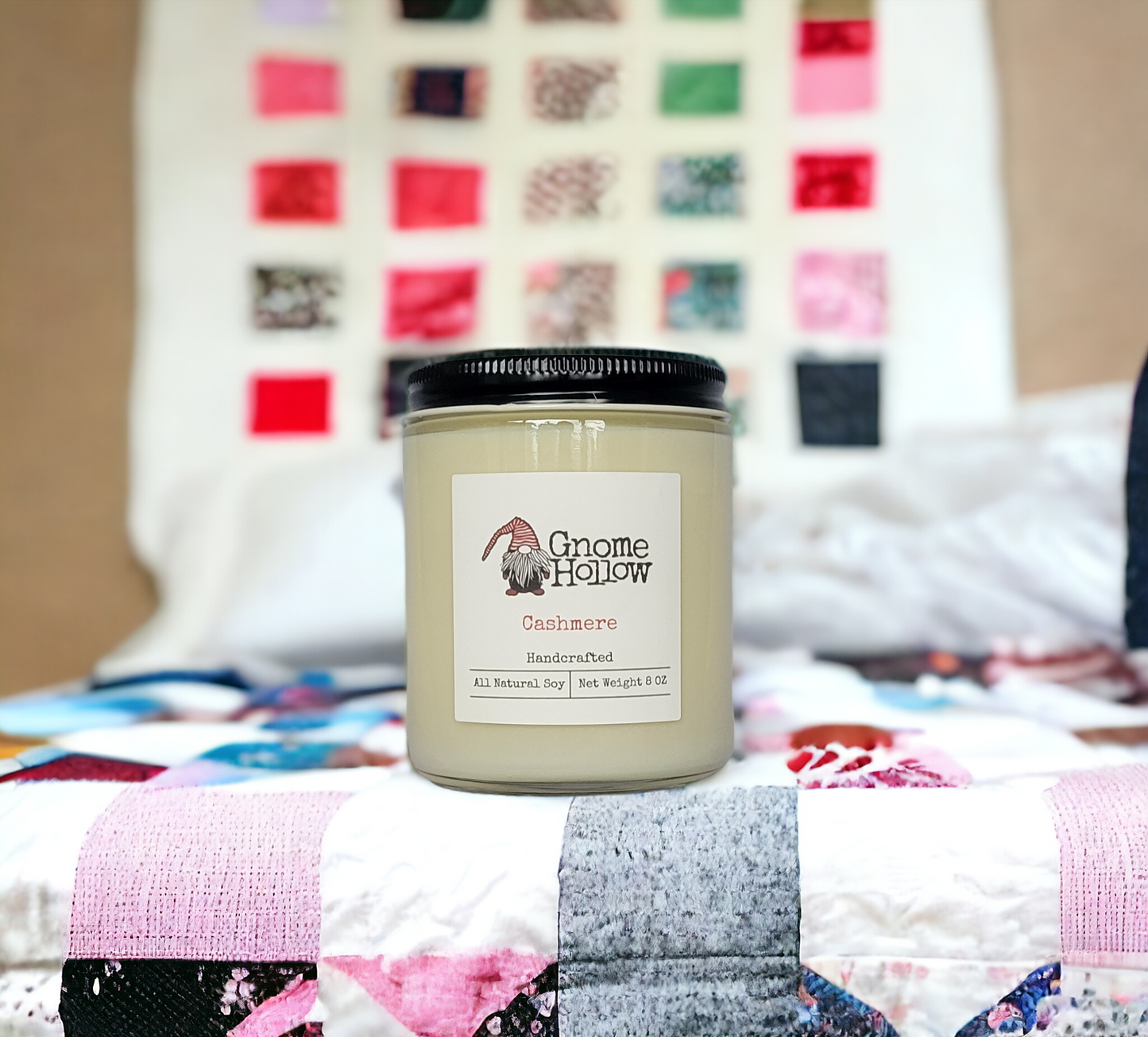 Cashmere candle sitting on a quilt with a blurred background