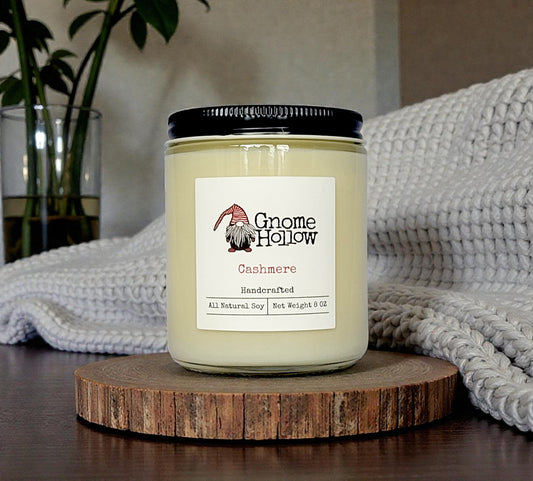 Candle at the end of a bed with a blanket