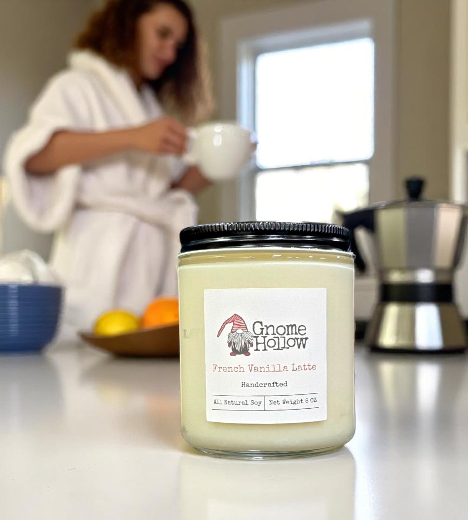 French Vanilla Latte candle on a kitchen counter with a blurred person in the background