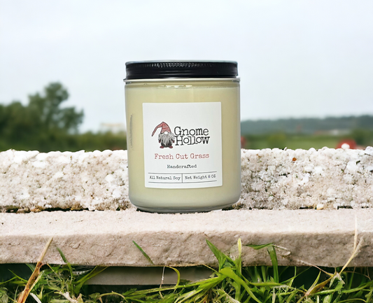 Fresh Cut Grass candle on a stone ledge with a blurred natural background
