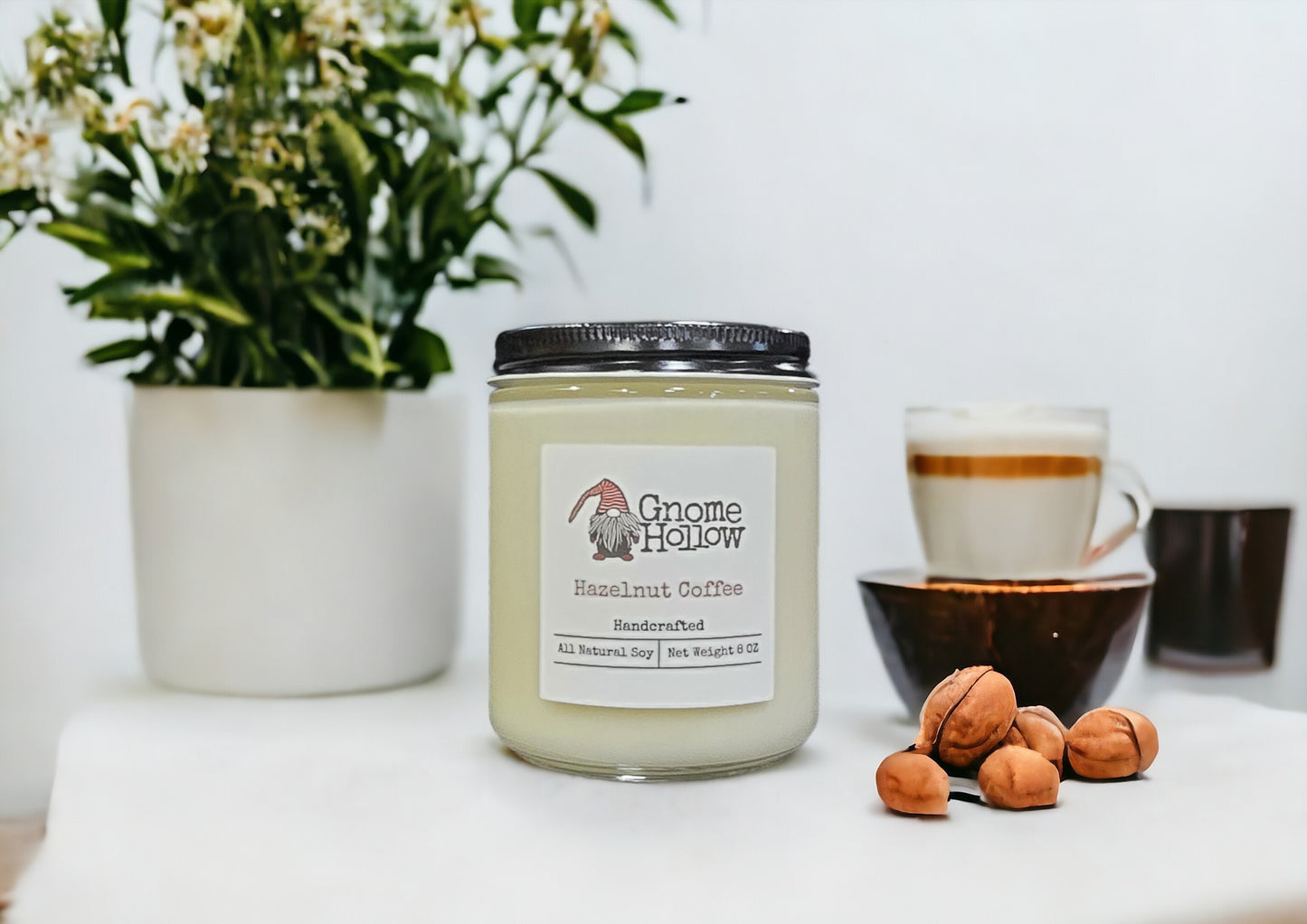 Hazelnut Coffee candle displayed with hazelnut & a cup of coffee to the side