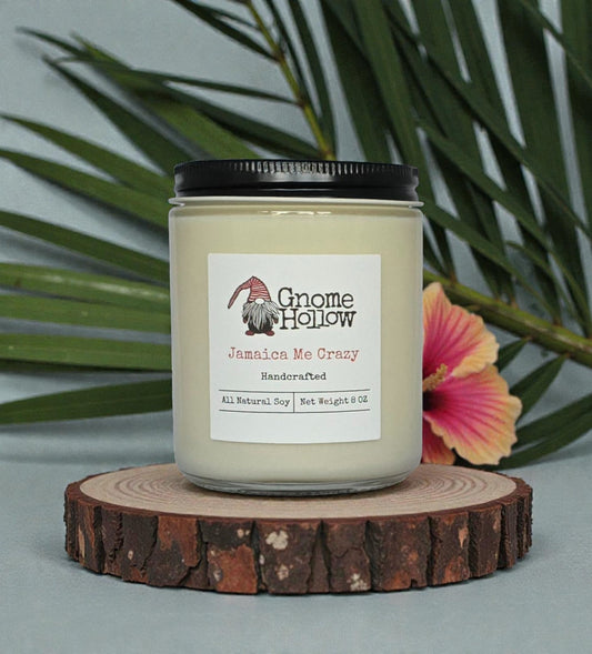 Candle on a round piece of wood with ferns & flowers in the background