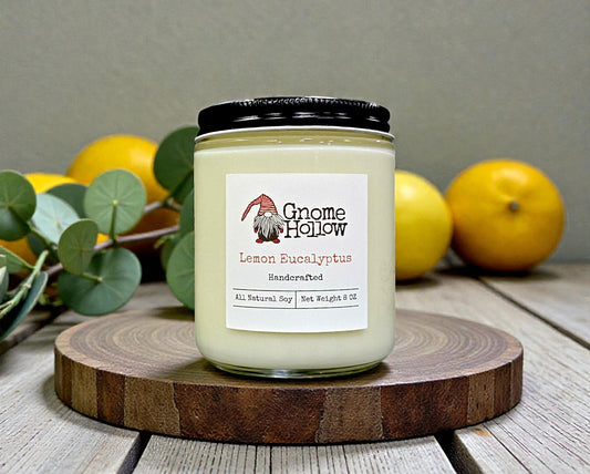 Gnome Hollow Lemon Eucalyptus candle on a wooden board with lemons and leaves in the background.