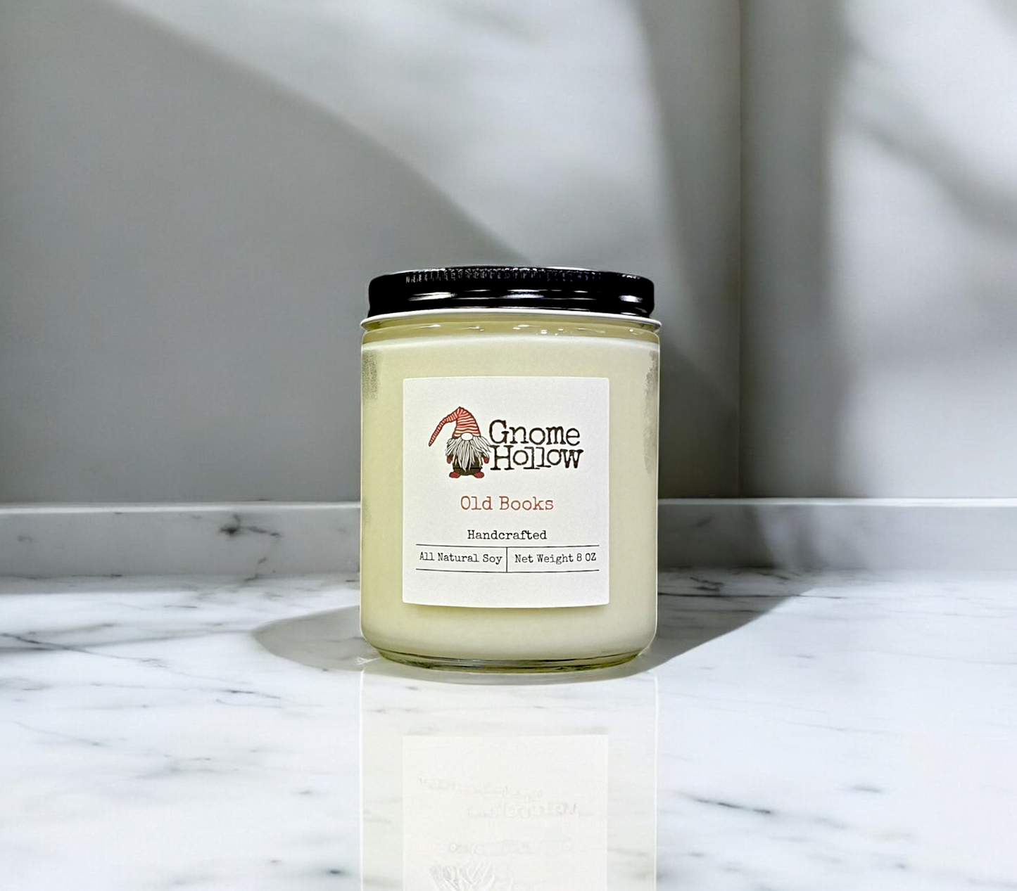 Old Books candle on a marble surface with a neutral background