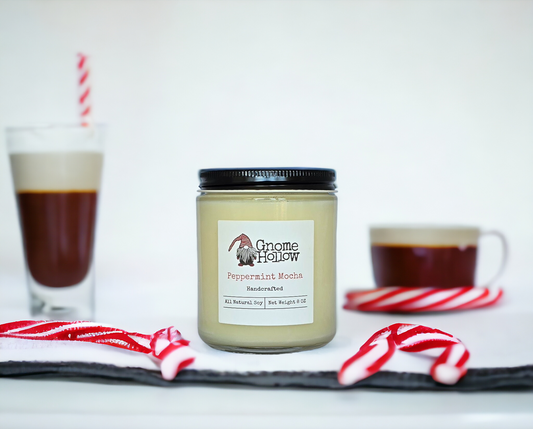 Peppermint + Mocha candle sitting on a white counter surrounded by candy canes and mocha cups