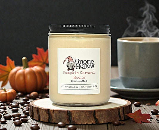 candle by a hot drink and pumpkins