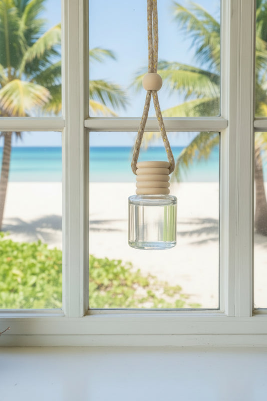 Hanging glass diffuser with lemons on a windowsill with a lemon tree outside.
